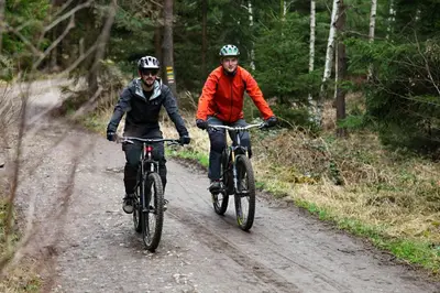 two men riding bikes down a dirt road at Boutique hotel Corso in Řevnice