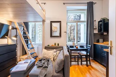 a living room with a couch and a table at Prague Days - Minimalistic Studio with Netflix and View to National Museum in Prague