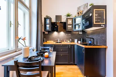 a kitchen with a table and a counter top at Prague Days - Minimalistic Studio with Netflix and View to National Museum in Prague