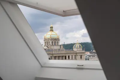 a bedroom with a bed with a plate of food on it at Prague Days - Minimalistic Studio with Netflix and View to National Museum in Prague
