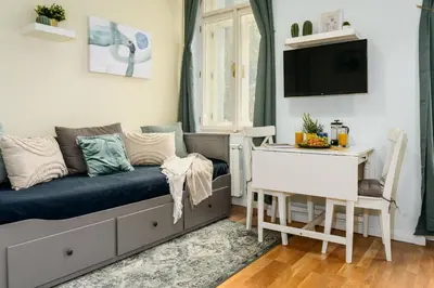 a living room with a couch and a table at Prague Days - Minimalistic Studio with Netflix and View to National Museum in Prague
