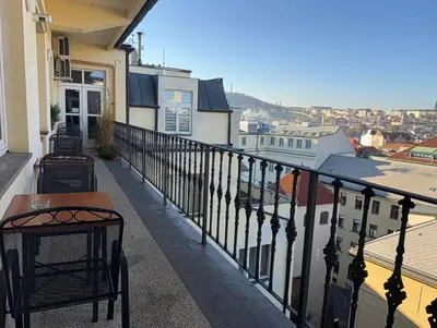 a balcony with a table and chairs on a building at Apartmán Kaiser in Prague