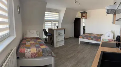 a small room with a bed and a desk and a bed and a desk at Apartmán Kaiser in Prague