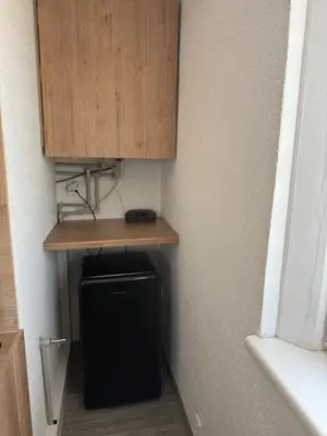 a room with a cabinet and a refrigerator under a shelf at Apartmán Kaiser in Prague