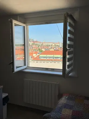 a bedroom with a window with a view of a building at Apartmán Kaiser in Prague
