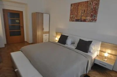 a bedroom with a large bed and a mirror at Jiřina Appartments in Prague