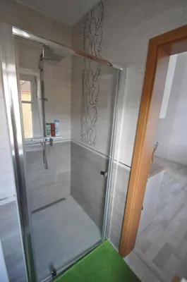 a shower with a glass door in a bathroom at Jiřina Appartments in Prague
