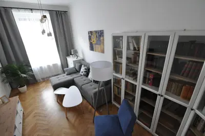 a living room with a couch and a table and bookcases at Jiřina Appartments in Prague
