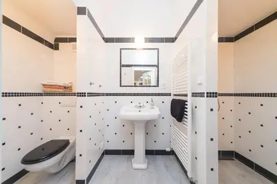 a white bathroom with a sink and a toilet at Budyne Apartment II. in Budyně nad Ohří