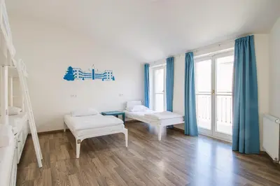 a room with two beds and blue curtains at Safestay Prague Charles Bridge in Prague