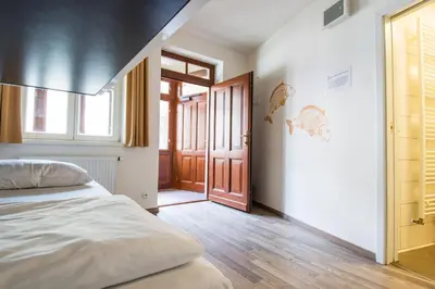 a bedroom with a bed and an open door at Safestay Prague Charles Bridge in Prague