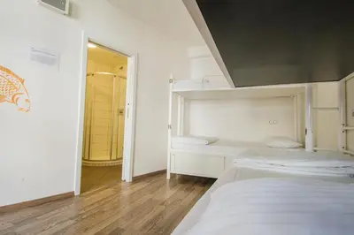a white room with two beds and a mirror at Safestay Prague Charles Bridge in Prague