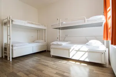 two bunk beds in a room with wooden floors at Safestay Prague Charles Bridge in Prague