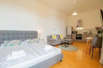 a bedroom with a large bed with blue curtains at Stay Inn Apartments Stepanska in Prague