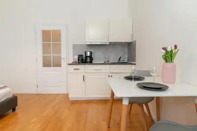 a kitchen with a table and two chairs and a tv at Stay Inn Apartments Stepanska in Prague