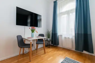 a living room with a television and a chair at Stay Inn Apartments Stepanska in Prague