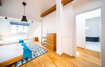 a bedroom with a bed and a dresser in a room at 5BR+3.5BT Wilson Central apt. in Prague