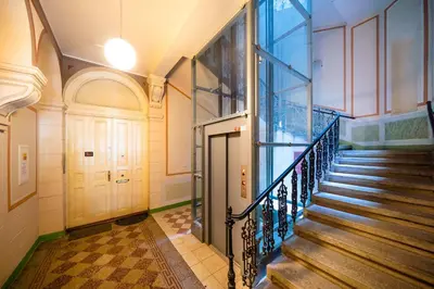 a hallway with stairs in a building with a door at Luxurious Woodrow Wilson apt in Prague centre in Prague