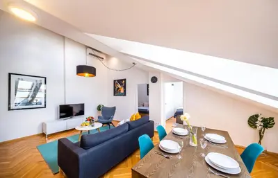 a living room with a table and blue chairs at Luxurious Woodrow Wilson apt in Prague centre in Prague