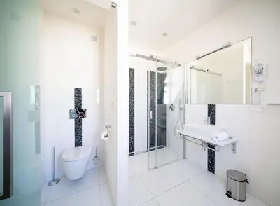 a white bathroom with a sink and a shower at Luxurious Woodrow Wilson apt in Prague centre in Prague