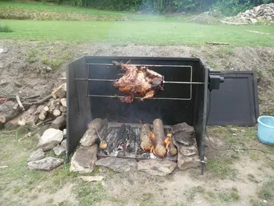a chicken is cooking in an outdoor oven at Penzion Venkoff in Sázava