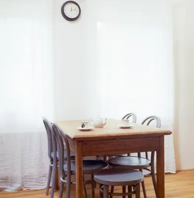 a dining room table with chairs and a clock on the wall at Penzion Venkoff in Sázava