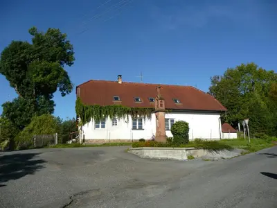 a white house with a red roof on a street at Penzion Venkoff in Sázava