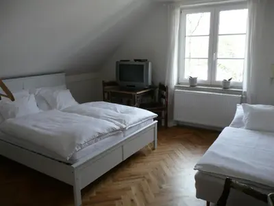 a bedroom with two beds and a tv on a table at Penzion Venkoff in Sázava