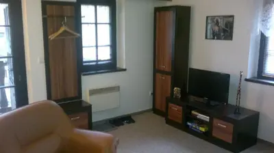 a living room with a couch and a television at U Královny Dagmar in Karlštejn
