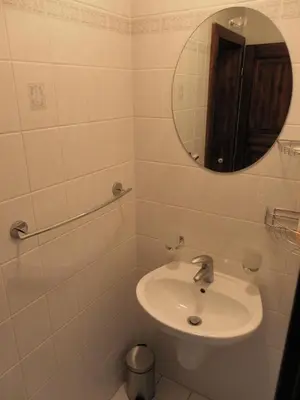 a white bathroom with a sink and a mirror at U Královny Dagmar in Karlštejn