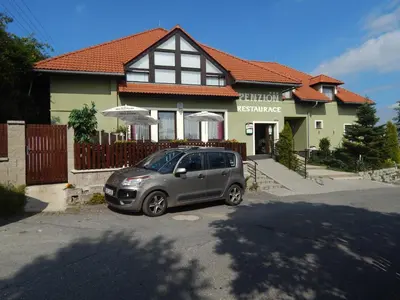 a small car parked in front of a house at Penzion U Kašných in Mníšek pod Brdy