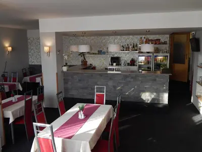 a restaurant with a table and chairs and a bar at Penzion U Kašných in Mníšek pod Brdy