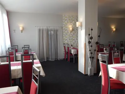 a dining room with tables and red chairs at Penzion U Kašných in Mníšek pod Brdy