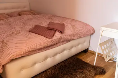 a bed with a pink comforter in a bedroom at Rezidence Hadovitá in Prague