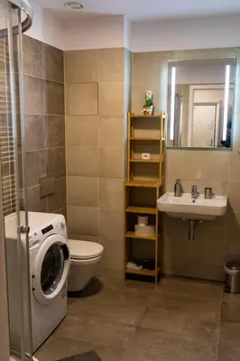 a bathroom with a washing machine and a sink at Rezidence Hadovitá in Prague