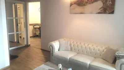 a living room with a couch and a painting on the wall at Rezidence Hadovitá in Prague
