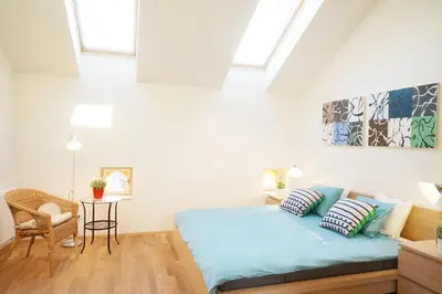 a bedroom with a bed and a chair at Naru house 9 in Prague
