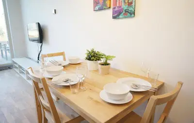 a wooden table with chairs and plates and wine glasses at Naru house 9 in Prague