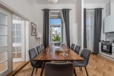a dining room with a wooden table and chairs at Centrally located 3BD home near National Museum in Prague