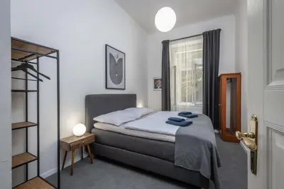 a small bedroom with a bed and a window at Centrally located 3BD home near National Museum in Prague