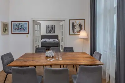 a dining room with a wooden table and chairs at Centrally located 3BD home near National Museum in Prague