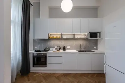 a kitchen with white cabinets and a sink at Centrally located 3BD home near National Museum in Prague