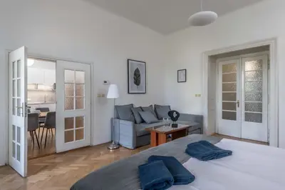 a white bedroom with a bed and a couch at Centrally located 3BD home near National Museum in Prague