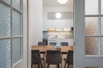 a kitchen and dining room with a wooden table and chairs at Centrally located 3BD home near National Museum in Prague