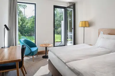 a bedroom with a bed and a desk and a chair at Hotel Golf Prague in Prague
