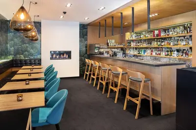 a restaurant with wooden tables and chairs and a bar at Hotel Golf Prague in Prague