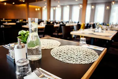 a table in a restaurant with a bottle of water on it at Hotel Golf Prague in Prague