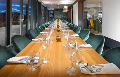 a long wooden table with wine glasses on it at Hotel Golf Prague in Prague