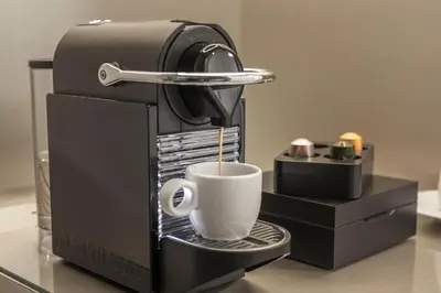 a coffee maker is making a cup of coffee at Hotel Golf Prague in Prague
