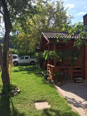 a log cabin with a yard and a car parked at Camping Matyáš in Vrané nad Vltavou